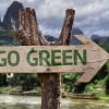 El camino hacia la sostenibilidad: Qué significa 'Go Green' hoy en díaEsta inspiradora imagen muestra un letrero rústico de madera tallada en forma de flecha que apunta hacia la derecha. En el centro del cartel, las palabras 